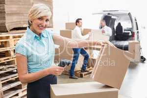 Smiling warehouse manager scanning package