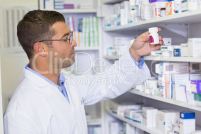 Handsome pharmacist holding medicine jar