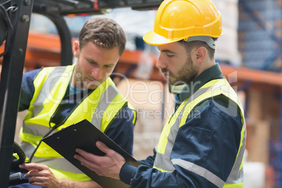 Focused warehouse workers talking together