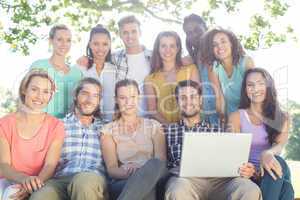 Friends looking at laptop in the park