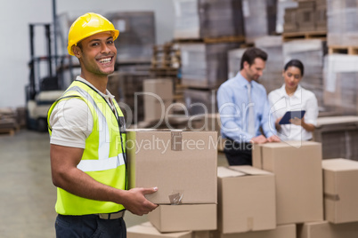 Worker carrying box in warehouse