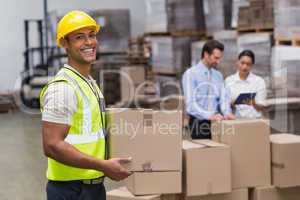 Worker carrying box in warehouse