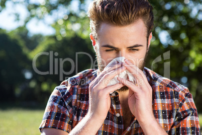 Handsome hipster blowing his nose