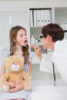 Doctor examining little girl mouth