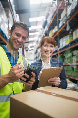 Worker and manager scanning package in warehouse