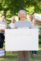 Happy volunteer grandmother holding blank