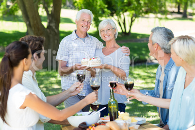 Happy couple holding cake at the park