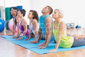 People doing yoga stretch in gym class