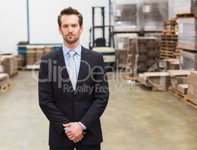 Warehouse manager standing hands together