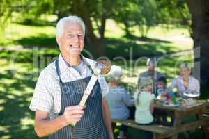 Happy grandfather doing barbecue