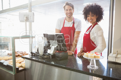 Portrait of colleagues posing behind the counter