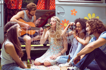 Hipster friends by camper van at festival