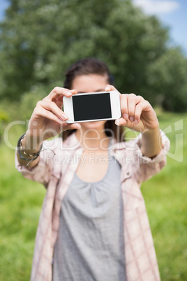 Pretty brunette taking a selfie in park