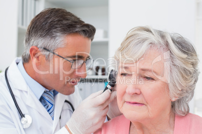 Doctor examining patients ear with otoscope Doctor examining patients ear with otoscope