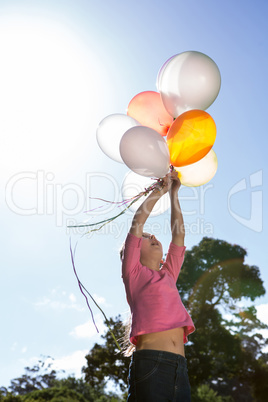 Happy little girl holding balloons