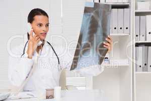 Doctor on the phone analysing xray results