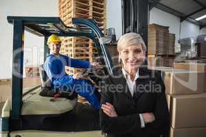 Smiling warehouse manager standing with arms crossed