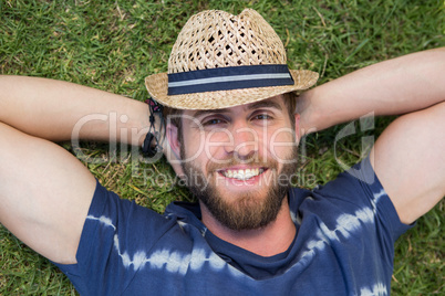 Handsome hipster lying on grass