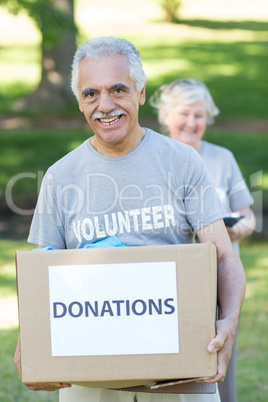 Happy volunteer senior holding donation box