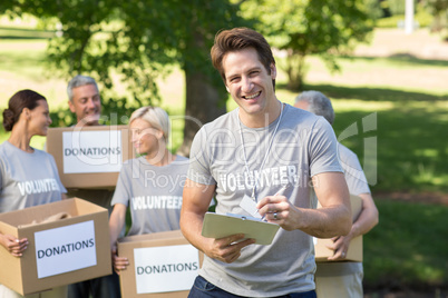 Happy volunteer man writing in clipboard