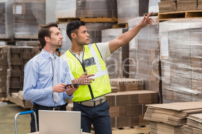 Warehouse worker showing something to his manager