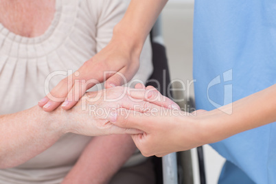 Nurse checking flexibility of patients wrist in clinic