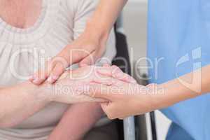 Nurse checking flexibility of patients wrist in clinic