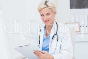 Confident female doctor holding clipboard