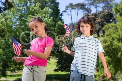 Little siblings waving american flag