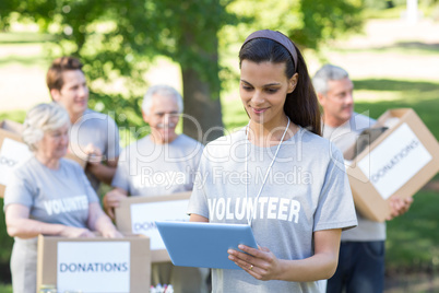 Smiling volunteer brunette using tablet pc