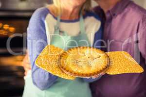 Mature blonde holding fresh pie with husband kissing her