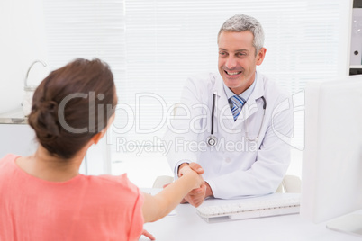 Happy doctor handshake at his patient