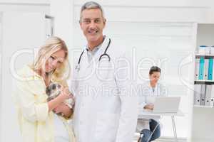 Veterinarian and cat owner smiling at camera