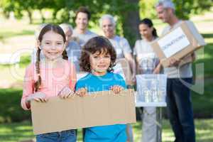 Happy siblings holding blank