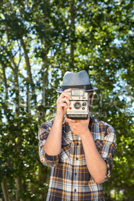 Handsome hipster using vintage camera