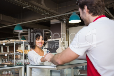 Smiling waiter doing transaction with customer