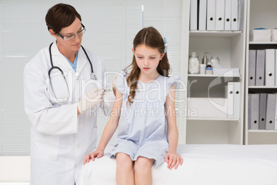 Doctor doing injection at a little girl