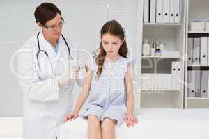Doctor doing injection at a little girl