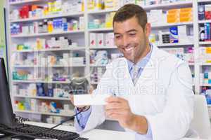 Handsome pharmacist scanning medicine box