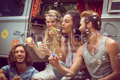 Hipsters blowing bubbles in camper van