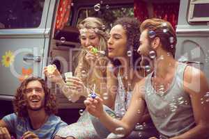 Hipsters blowing bubbles in camper van