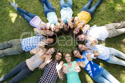 Happy friends in the park lying in circle