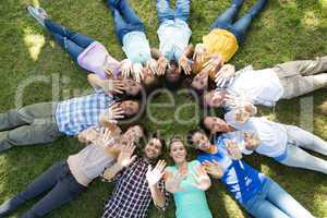 Happy friends in the park lying in circle