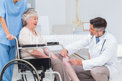 Doctor examining senior womans knee
