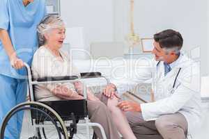 Doctor examining senior womans knee