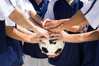 Pretty football players putting hands together