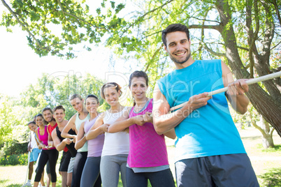 Fitness group playing tug of war