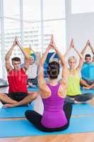 People practicing yoga in fitness club