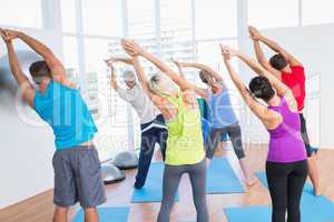 People doing stretching exercise in yoga class