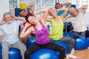 People on fitness balls exercising in gym class